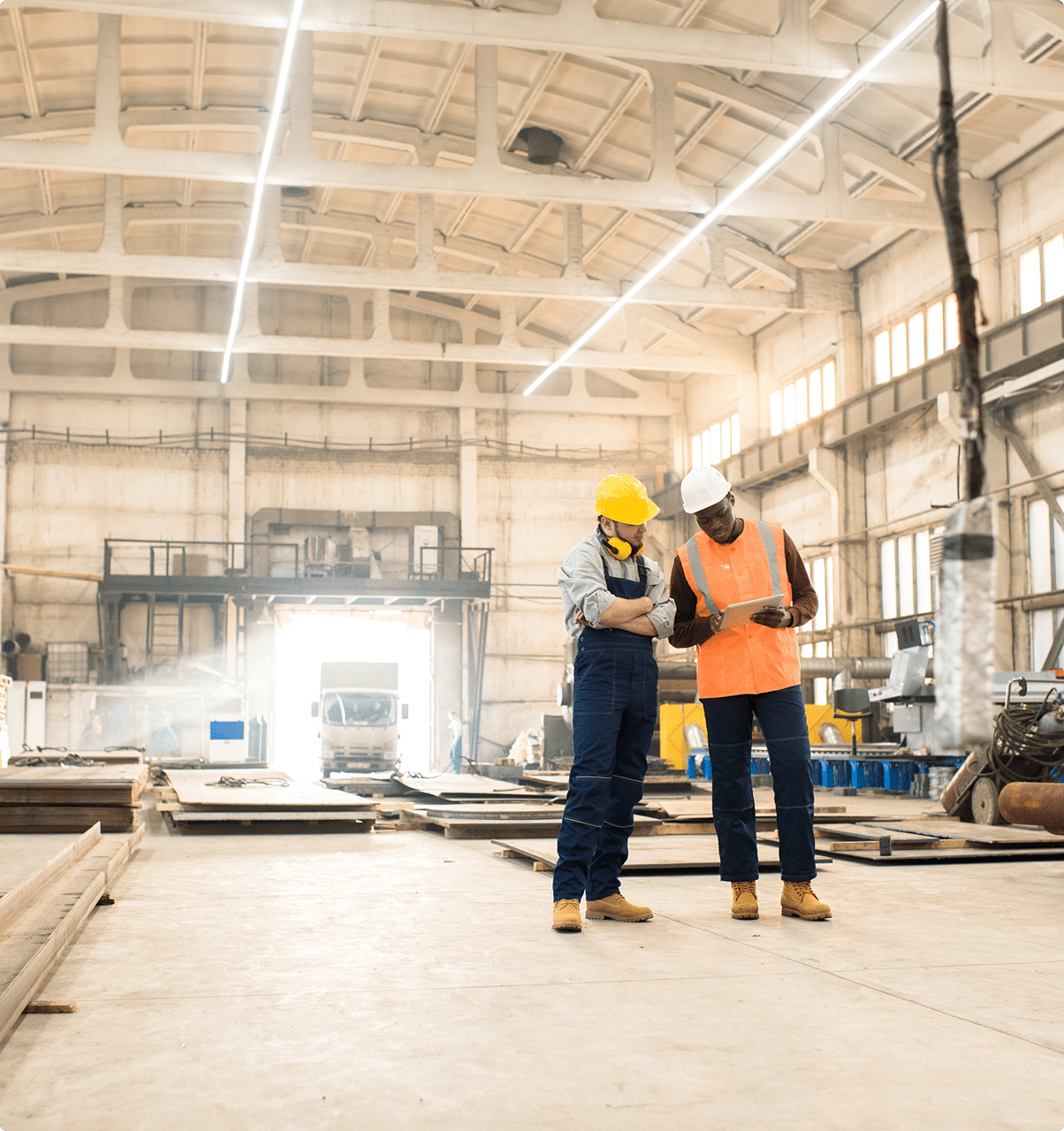 Two workers in hard hats and safety vests inside an industrial facility – builder's risk insurance common scenarios | CRS Group Nebraska