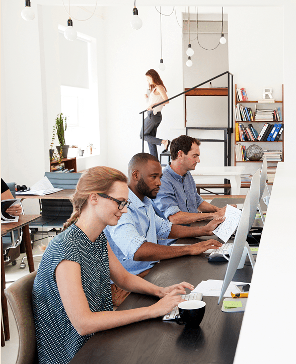 Diverse team of employees working at computers in an office – employee benefits Nebraska | CRS Group