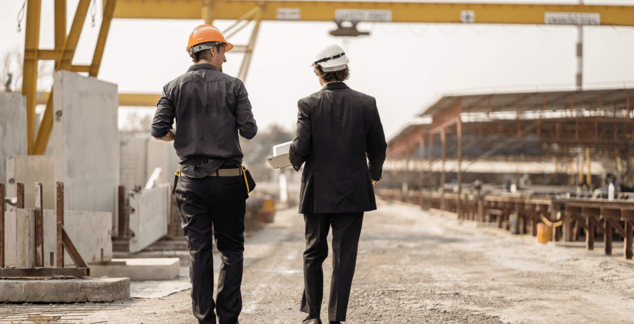 Two contractors walking a large construction site – surety bonds Nebraska | CRS Group