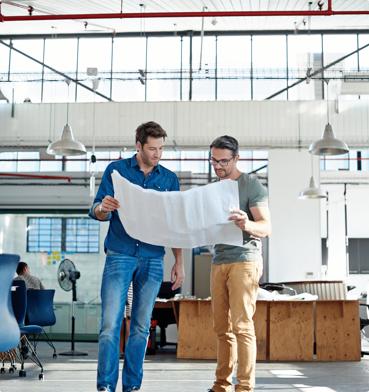 Two professionals reviewing blueprints together – what working with CRS Group looks like