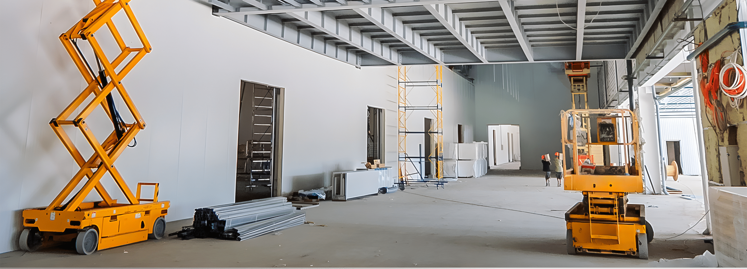 Interior of a commercial building under construction with scissor lifts – CRS Group builder's risk insurance Nebraska