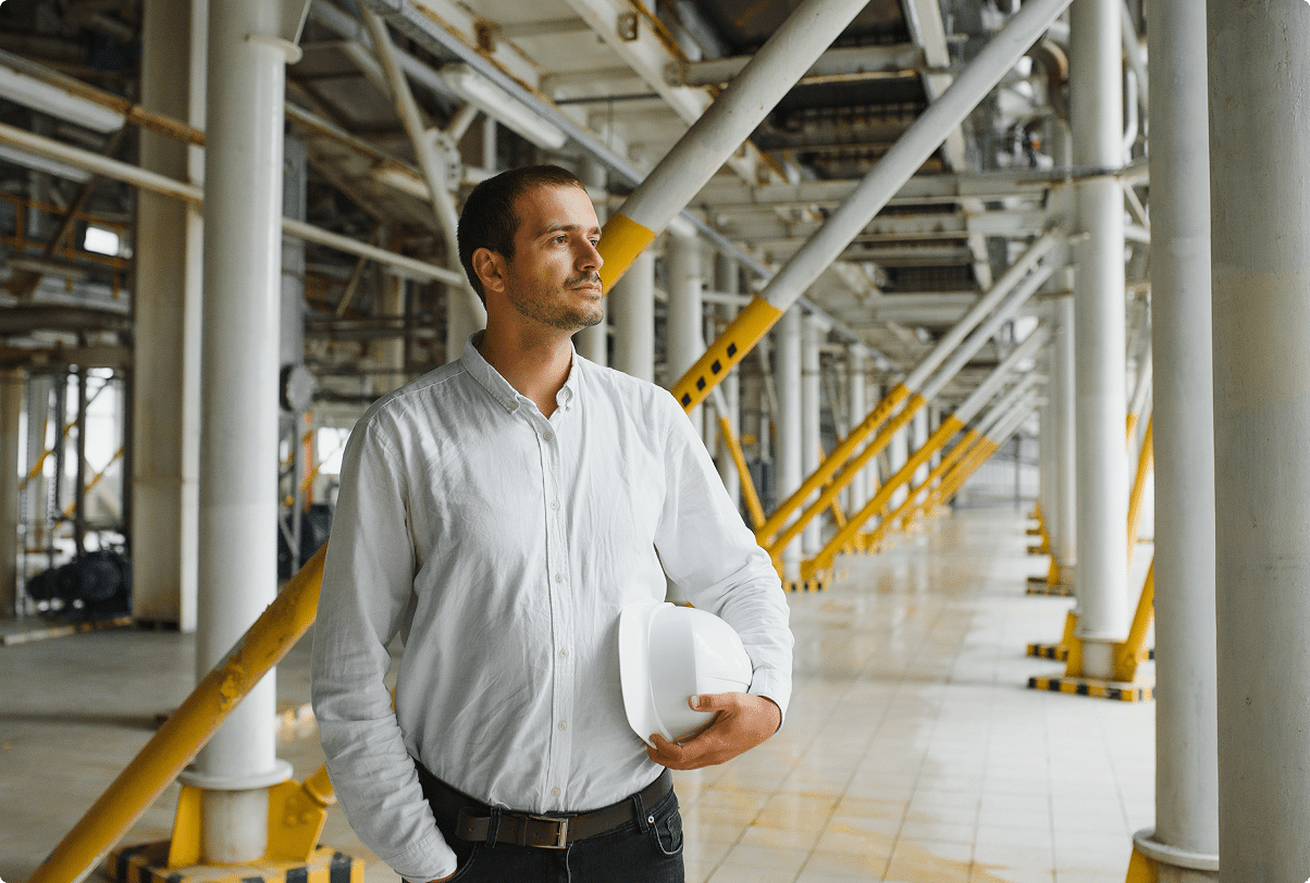 Business owner holding a hard hat at a commercial job site – CRS Group insurance client